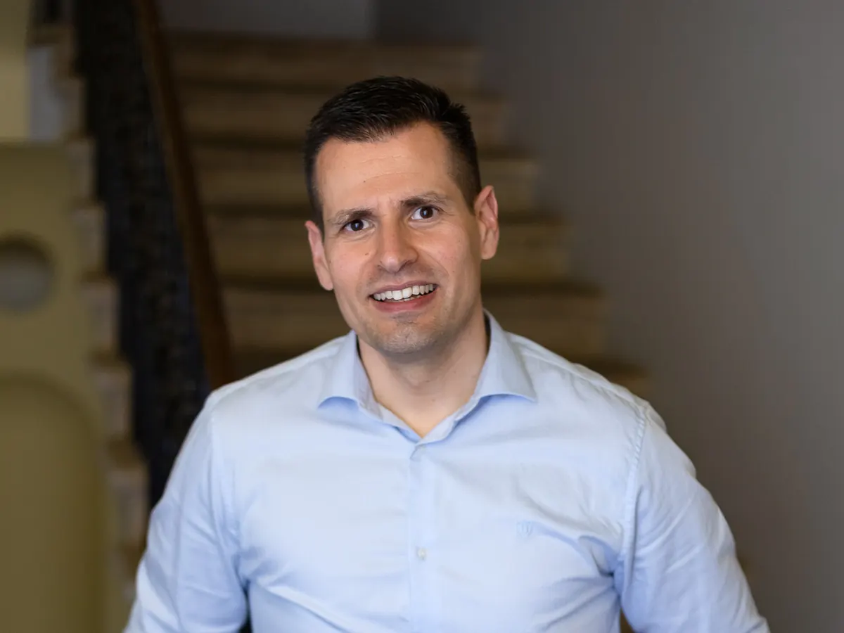 Martin Kadeřábek se usmívá na schodišti