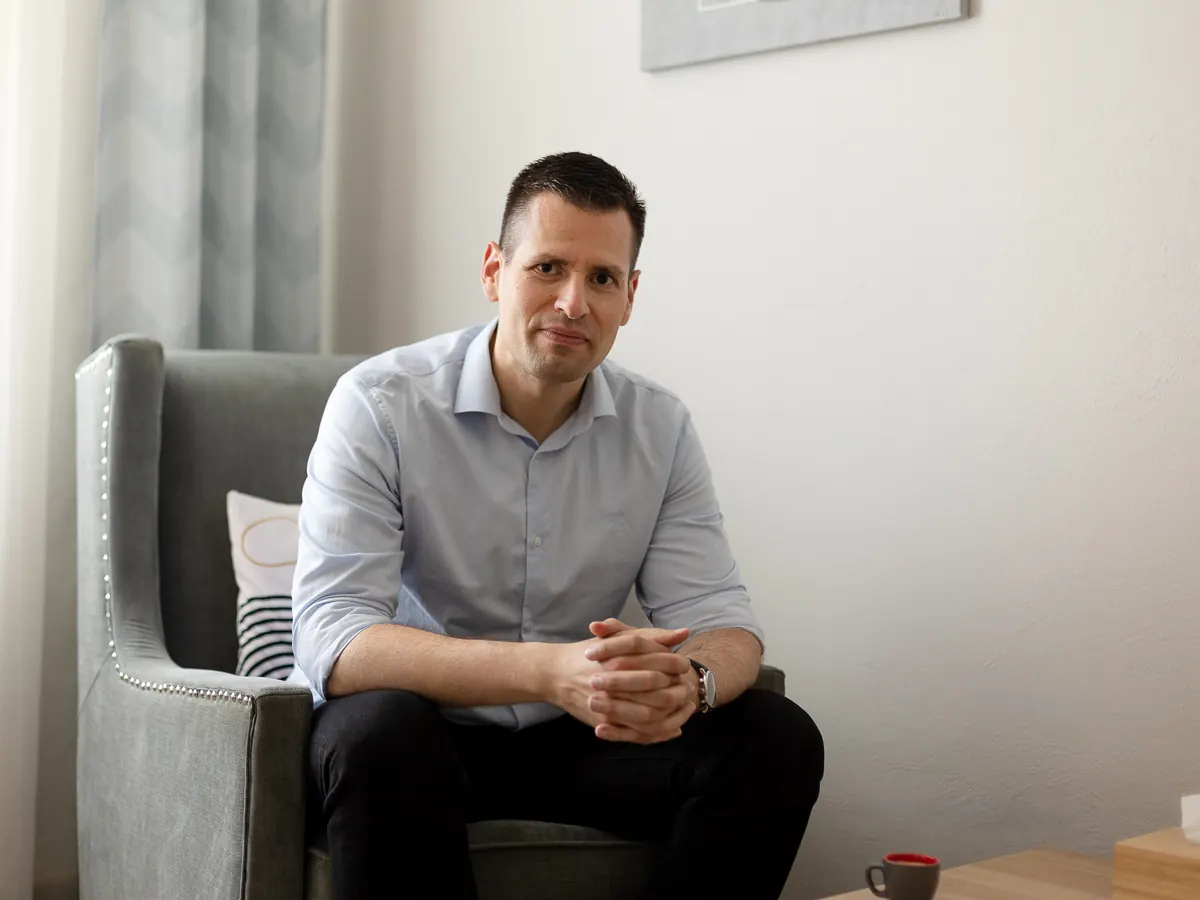 Martin Kadeřábek v terapeutické místnosti, v pozadí okno se záclonou