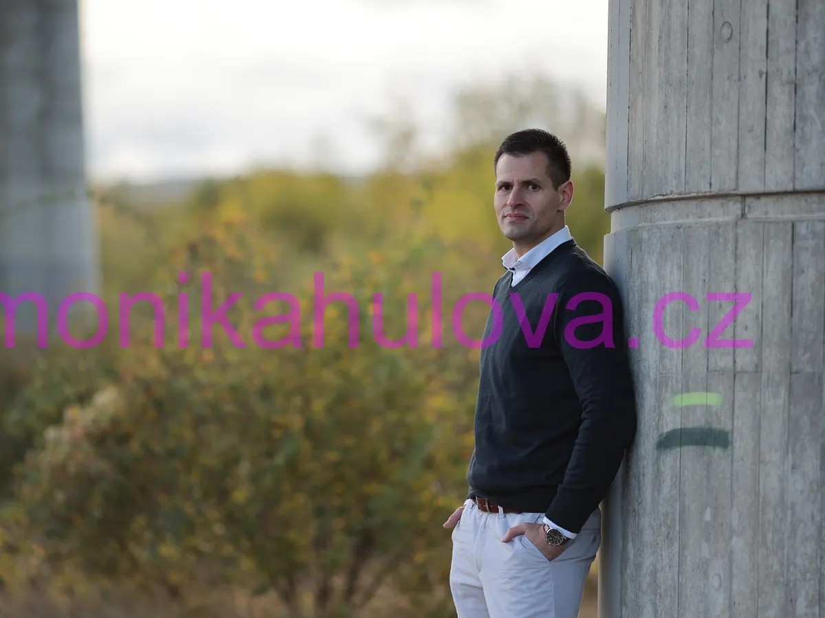Martin Kadeřábek stojí opřený o betonový pilíř a dívá se do objektivu