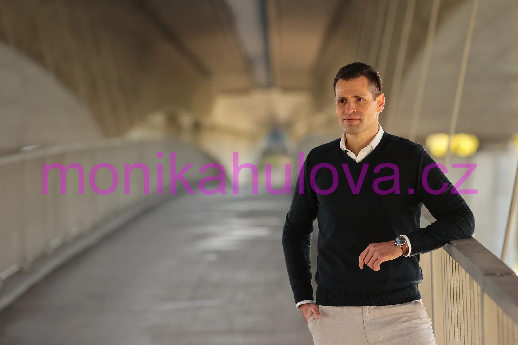 Martin Kadeřábek stojí na lávce a dívá se doleva k nadpisu